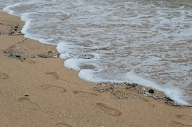 Tayland 'daki kirli, sessiz sahilde küçük bir dalga.