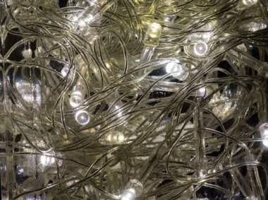 Aydınlık cam şişesinde elektrik teli olan bir sürü LED ampul var. Işığın gücü şişedeki nemden su damlatıyor.