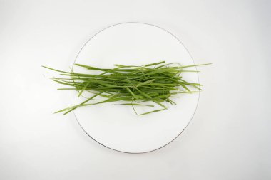 beyaz bir tare üzerinde çim, çatal ile