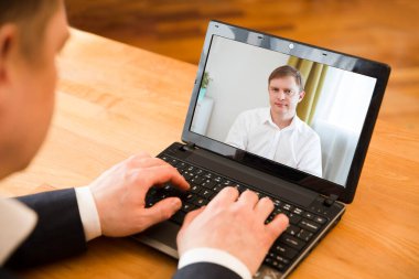 Online konferans. İş adamı iş ortağına bilgisayar kullanarak video görüşmesi yapıyor. Merkez ofis. Evden çalışmak.