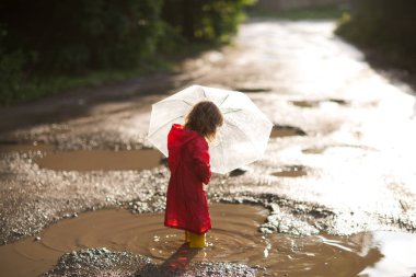 Şemsiyeli mutlu çocuk da yazın açık havada havuzlarda yürür.