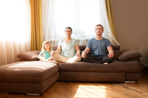 Familia Con Pequeña Hija Preescolar Sentarse Sofá Practicar Yoga Juntos — Foto de Stock