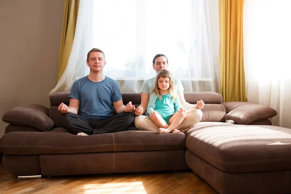 Familia Con Pequeña Hija Preescolar Sentarse Sofá Practicar Yoga Juntos —  Fotos de Stock