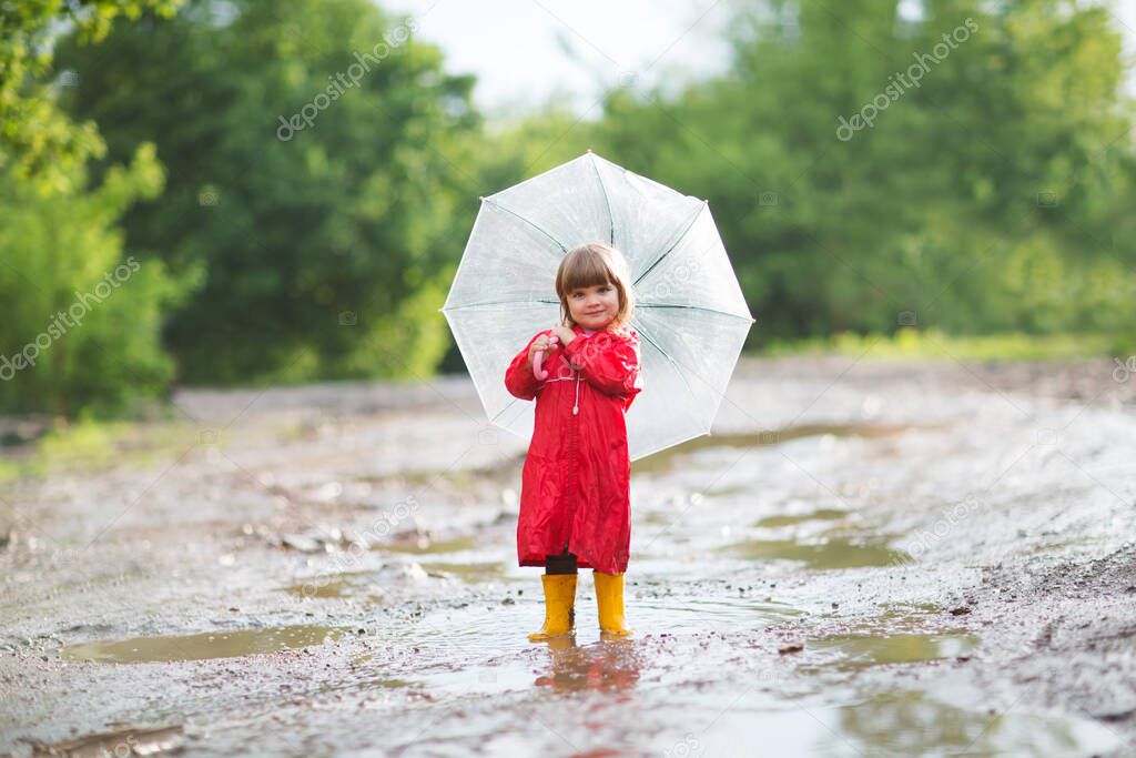 Happy child  with an umbrella playing also walks on pools in the summer outdoors