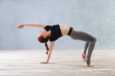 Şehir geçmişinde yoga yapan genç bir kadın. Bir dizi yoga pozu. Fitness, spor, yoga - konsept.