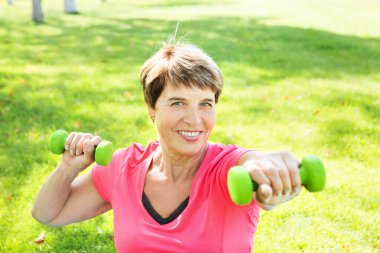 Dışarıda egzersiz yapan yaşlı bir kadın. tek başına açık hava aktiviteleri. Sosyal Mesafe 