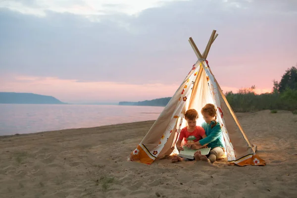 Two Children Reading Book Flashlights Tent Evening River Bank — Stock Photo, Image