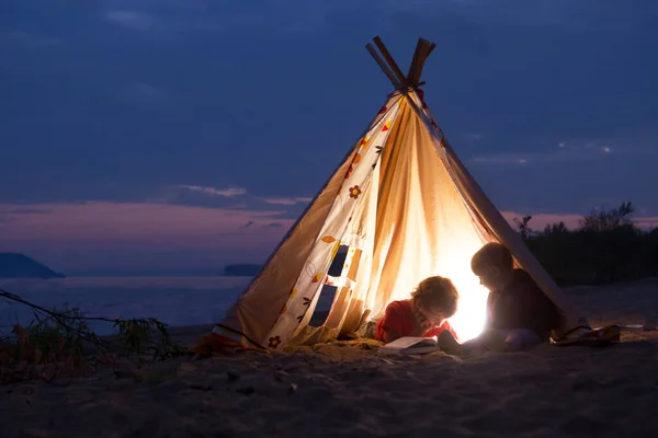 Two Children Reading Book Flashlights Tent Evening River Bank — Stock Photo, Image