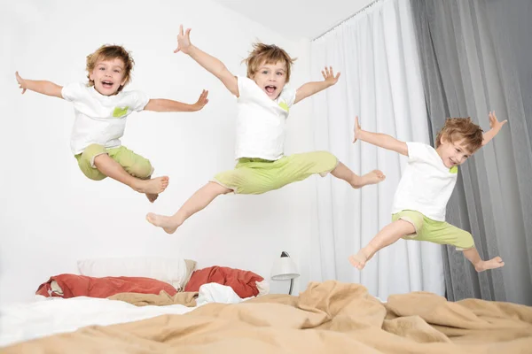 Alegre Niño Saltando Cama Casa —  Fotos de Stock