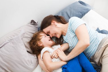 Anne ve küçük oğlu hafta sonu yatakta oynuyorlar. Tembel bir sabah..