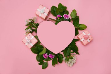 Çiçekler, yapraklar, kağıt kalp ve pastel arka planda hediyeler içeren yaratıcı bir düzen. tatil konsepti. Düz yerde, üst tarafta. Sevgililer Günü ile