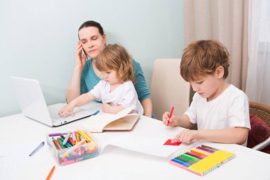 Merkez ofis. Evden çalışmaya karşı. İki çocuklu anne evde dizüstü bilgisayarda çalışıyor. Karantinaya alındı. Corona Virüsü. Evdeki yan koşuşturmalar. 