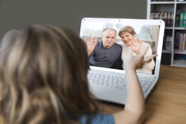 Çocuk dizüstü bilgisayar kullanıyor ve internetten büyükanne ve büyükbabasıyla iletişim kuruyor. Karantinaya alındı. Sağlık konsepti. Corona Virüsü.