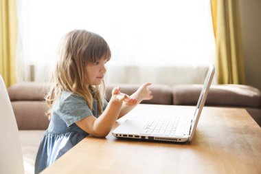 Çocuk bir dizüstü bilgisayar kullanıyor ve evdeki internet üzerinden iletişim kuruyor. Eğitim çevrimiçi. Karantinaya alındı. Corona Virüsü. çocuk evde ders çalışıyor..
