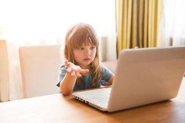 Çocuk bir dizüstü bilgisayar kullanıyor ve evdeki internet üzerinden iletişim kuruyor. Eğitim çevrimiçi. Karantinaya alındı. Corona Virüsü. çocuk evde ders çalışıyor..