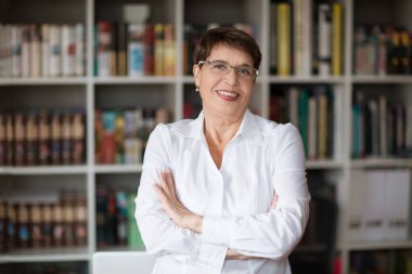 Kıdemli bayan öğretmen evde online ders yaparken kameraya bak. İş kadını konferansta.