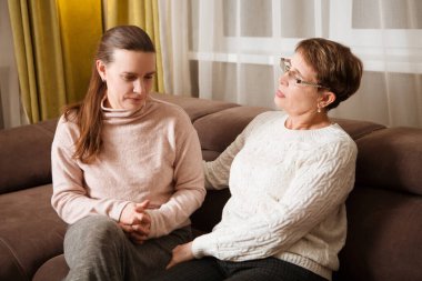 Mutlu yaşlı bayan anne ve yetişkin kız içeride sarılıyorlar. Aile zamanı. .
