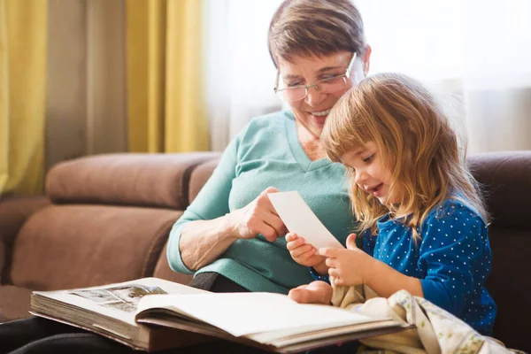 Grandmother reading a tale to her baby granddaughter. Family Reading Leisure. Quality Time. Happy Family having fun playing at home.