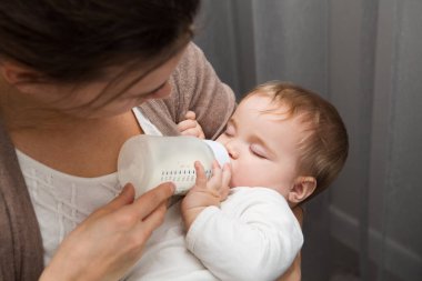 Süt şişesi olan sevimli bir bebek. Bebek sütü şişesi