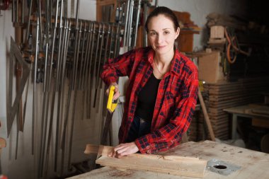 Marangoz kadın marangozluk atölyesinde işini yapıyor..