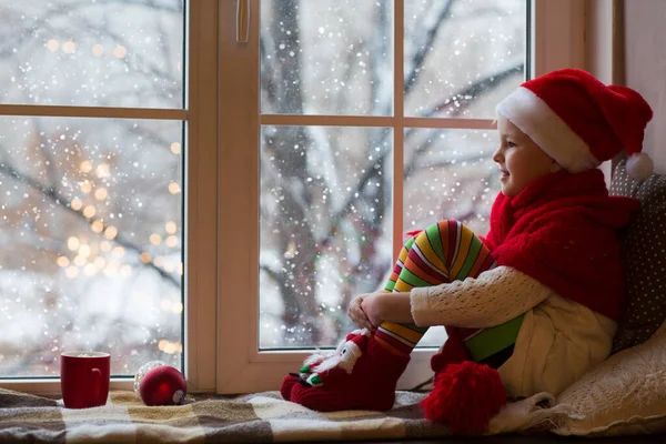 Cute Little Girl Sitting Window Looking Snow Room Decorated Christmas — Stock Photo, Image
