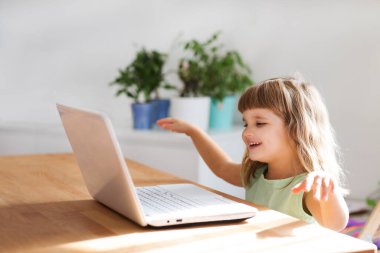 Çocuk bir dizüstü bilgisayar kullanıyor ve evdeki internet üzerinden iletişim kuruyor. Eğitim çevrimiçi. Karantinaya alındı. Corona Virüsü. çocuk evde ders çalışıyor..