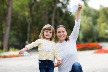 Dışarıda tıbbi maskeli bir anne. yeni normal.