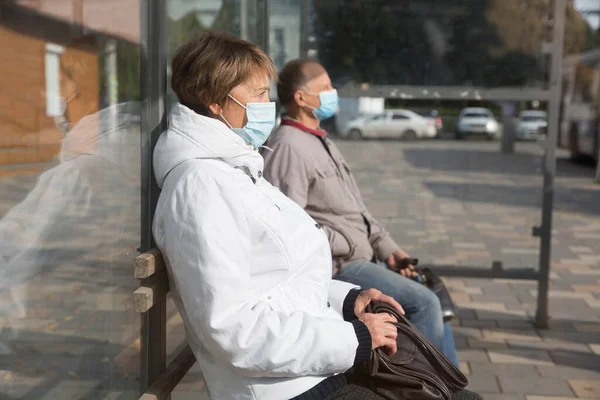 社会距离 头戴口罩的老年人在巴士站等着 新常态 — 图库照片
