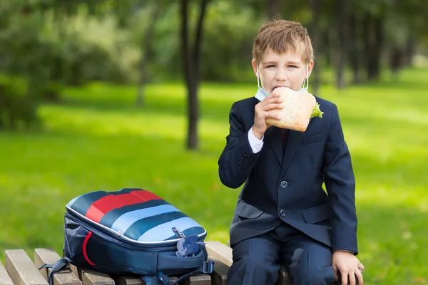 Schooljongen Die Zijn Medisch Masker Afdoet Buiten Een Broodje Eet — Stockfoto