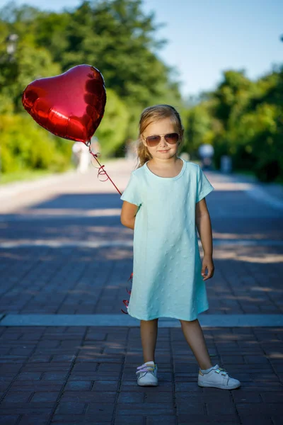 little girl with a heart-shaped balloon