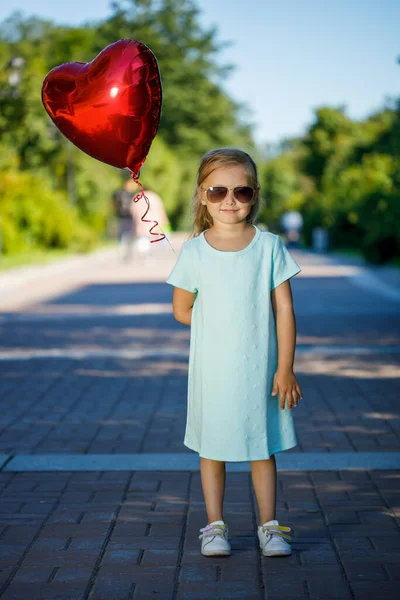 little girl with a heart-shaped balloon