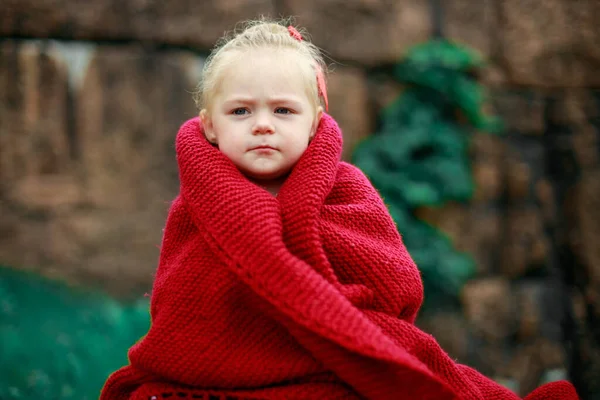 girl in the park wrapped in a woolen shawl