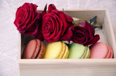 güzel güller, closeup ile bir kutu içinde parlak renklerin macaroons, badem çerezler