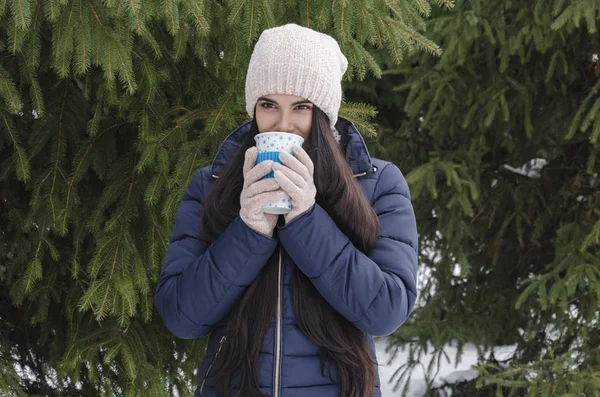 Mladá Dívka Termo Hrnek Horkým Nápojem Pozadí Zelené Jehličí Chladný — Stock fotografie