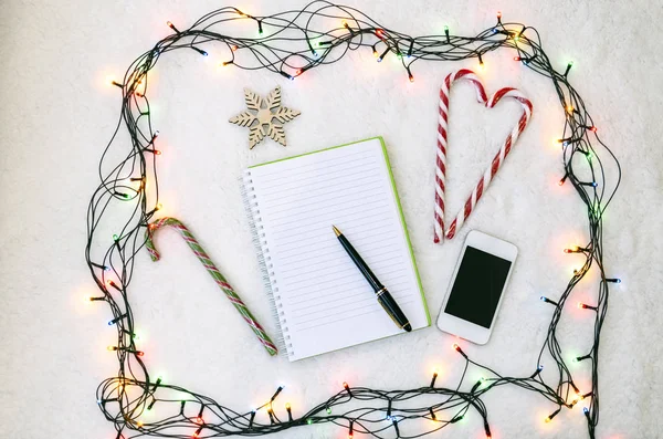 Notebook Toll Toll Telefon Candy Háttérben Karácsonyi Girland — Stock Fotó