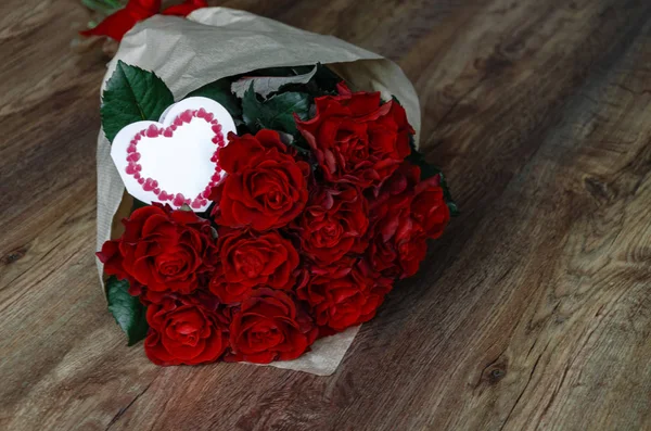 Ramo con rosas rojas sobre un fondo de madera — Foto de Stock