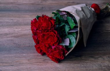 ahşap bir arka planda kırmızı güller ile buket