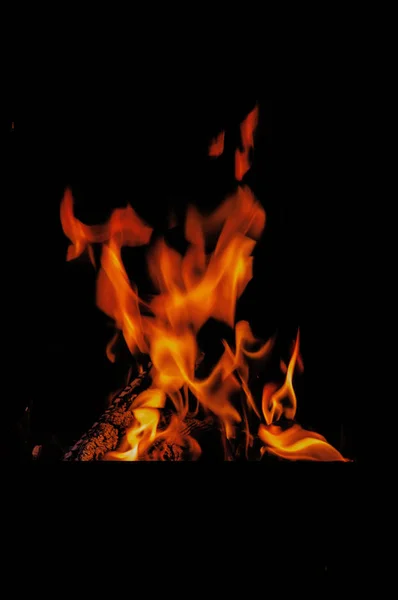 Rote Flamme, brennendes Holz, das Wärme und Licht spendet — Stockfoto