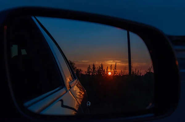 Espejo de coche con reflejo del cielo con puesta de sol — Foto de Stock