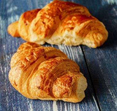 mavi ahşap arka plan üzerinde kruvasan