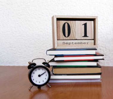 Eylül ilk tarihi ve bir çalar saat, masada renkli kalemler ile takvim