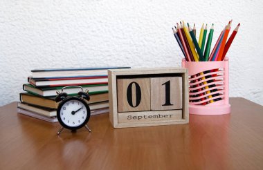 Eylül ilk tarihi ve bir çalar saat, masada renkli kalemler ile takvim