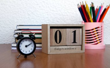 Eylül ilk tarihi ve bir çalar saat, masada renkli kalemler ile takvim