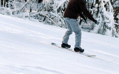Snowboardcu karlı bir inişten iniyor.