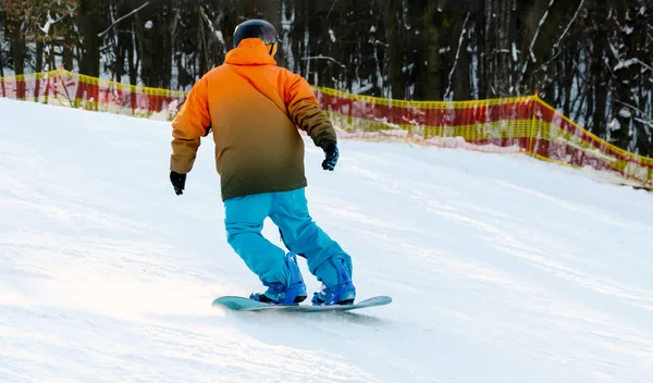 Snowboardista sestupuje ze zasněženého sestupu — Stock fotografie