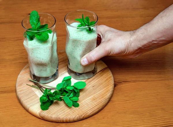 Yeşil naneli cam bir şişede smoothie ile erkek eli — Stok fotoğraf