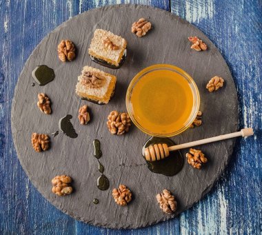 Taraklı bal, kahverengi bir tabakta fındıklı, yakın plan yiyecek.