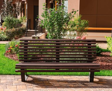 Sıcak bir günde şehir avlusunda dinlenmek için ahşap bank.