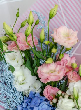 Östoma ve ortanca çiçekleri bir buketin içinde. Masadaki bayram hediyesi. Yakın plan.