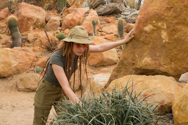Young male traveler in desert, woman hiker in cactus garden